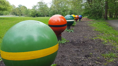 Multi colored balloons on field against trees