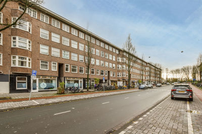 Cars on street against sky