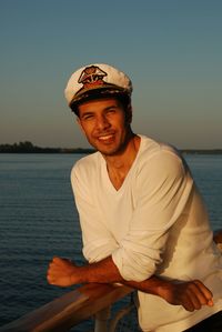 Portrait of young man sitting in sea against clear sky