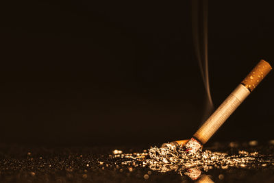 Close-up of illuminated cigarette against black background