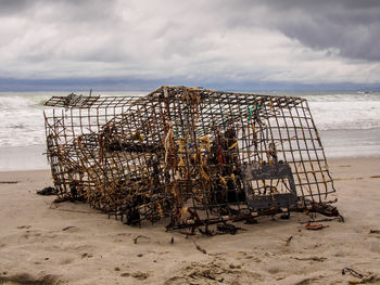 Lobster cage / trap / pot on the sandy beach by the atlantic ocean in maine, usa.