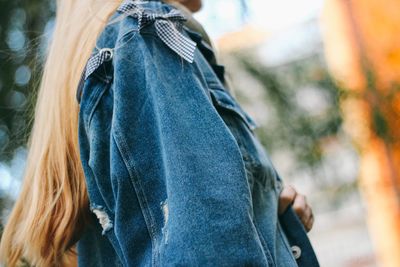 Midsection of woman wearing denim shirt outdoors