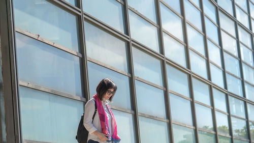 Side view of woman looking through window