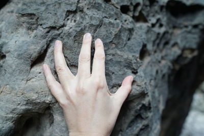 Close-up of human hand on rock