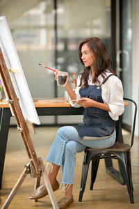 Woman painting on canvas at home