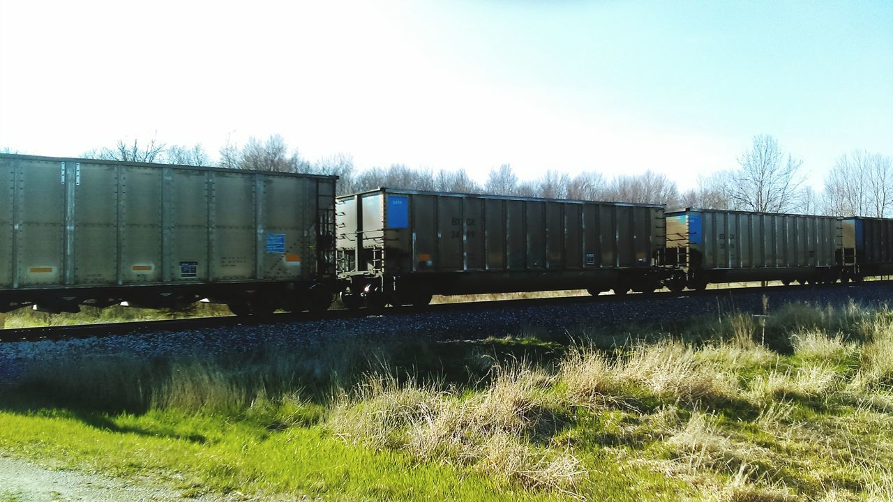 TRAIN BY RAILROAD TRACKS AGAINST CLEAR SKY
