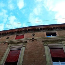 Low angle view of building against cloudy sky