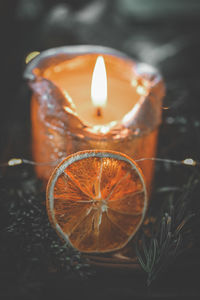 Close-up of lit candle on table