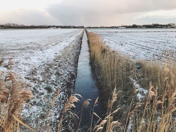 Scenic view of snow covered land against sky