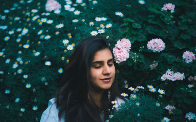 Portrait of beautiful woman with red flower