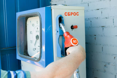 Cropped image of man holding fuel pump at gas station