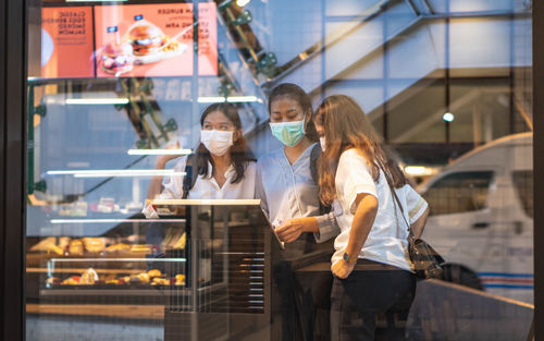 Group of people standing in glass building