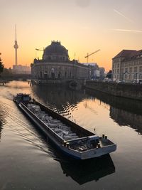 Boats in river at sunset