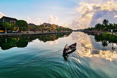 People on boat in lake against sky