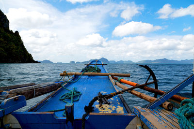 Fishing boats moored on sea against sky