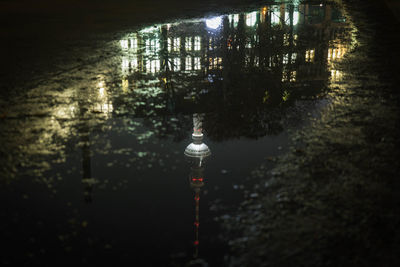 Reflection of television tower in puddle