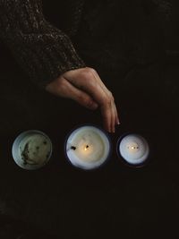 High angle view of woman holding burning candle