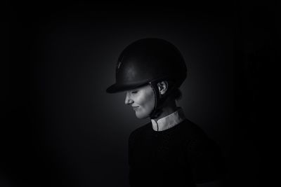 Boy wearing hat against black background