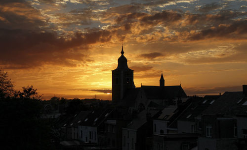 Buildings in city against sky during sunset