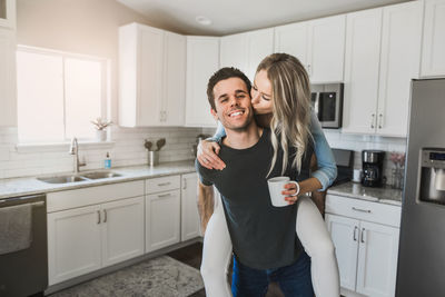 Smiling young woman standing at home