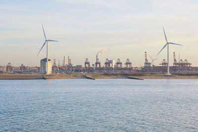 A commercial shipping dock with wind turbines in rotterdam, netherlands