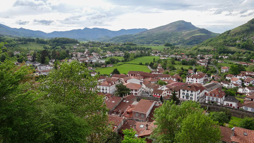 Aerial view of townscape by mountain against sky