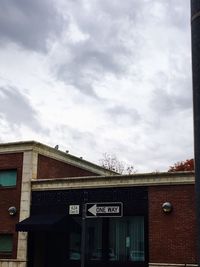 Low angle view of text on roof against sky