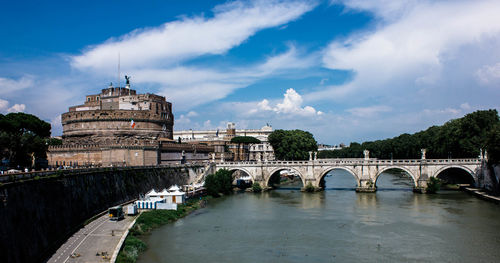 Arch bridge over river against buildings