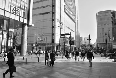 People walking on street against buildings in city