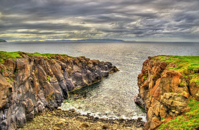 Rocks on sea shore against sky