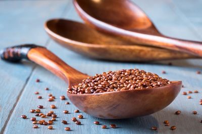 Close-up of quinoa seeds in wooden spoon on table