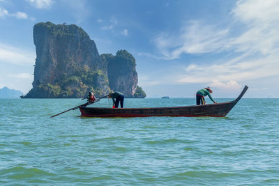 Fisherman fishing in sea against sky