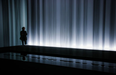 Silhouette man standing in illuminated room
