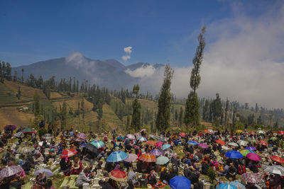 Group of people on mountain range against sky