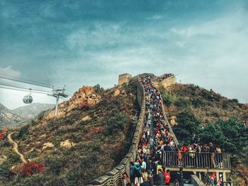 Tourists at great wall of china against blue sky