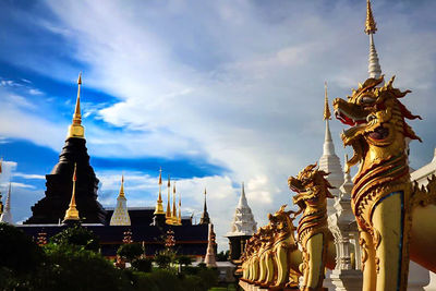 Low angle view of statue of temple against cloudy sky