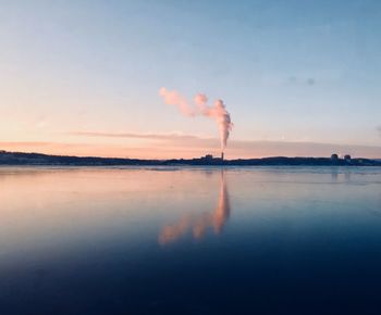 Smoke emitting from chimney against sky at sunset