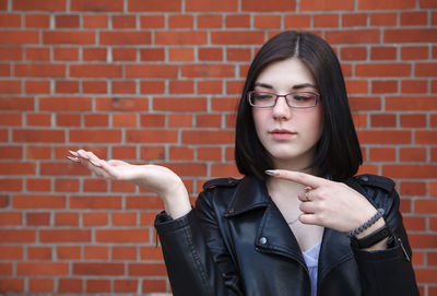 Portrait of teenage girl against brick wall