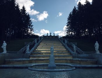 Staircase by lake against sky at dusk