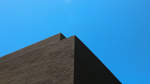 Low angle view of office building against blue sky