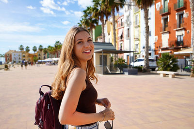 Portrait of happy carefree millennial tourist walking enjoying the city on summer. copy space.