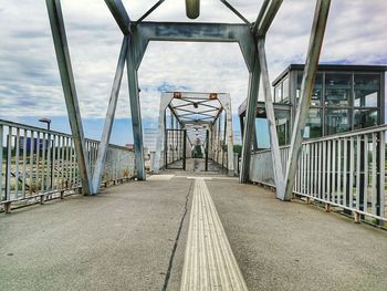 Empty footbridge against sky