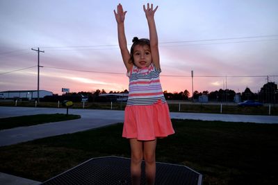 Portrait of smiling girl standing against sky during sunset