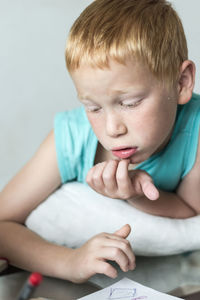 Close-up of boy sitting on table