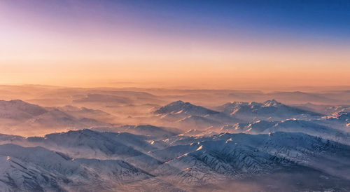 Scenic view of snowcapped mountains against sky during sunset