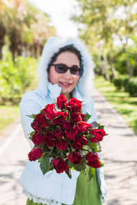 Portrait of woman holding red flower
