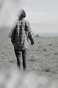 Rear view of woman standing by sea