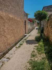 Footpath amidst buildings against sky