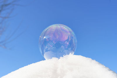 Close-up of bubbles in winter against blue sky