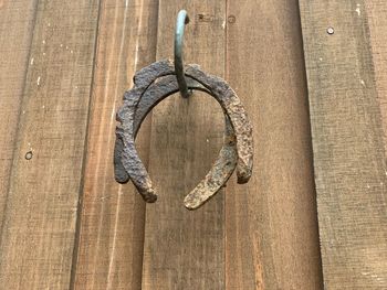 Close-up of rusty horseshoe hanging on wood